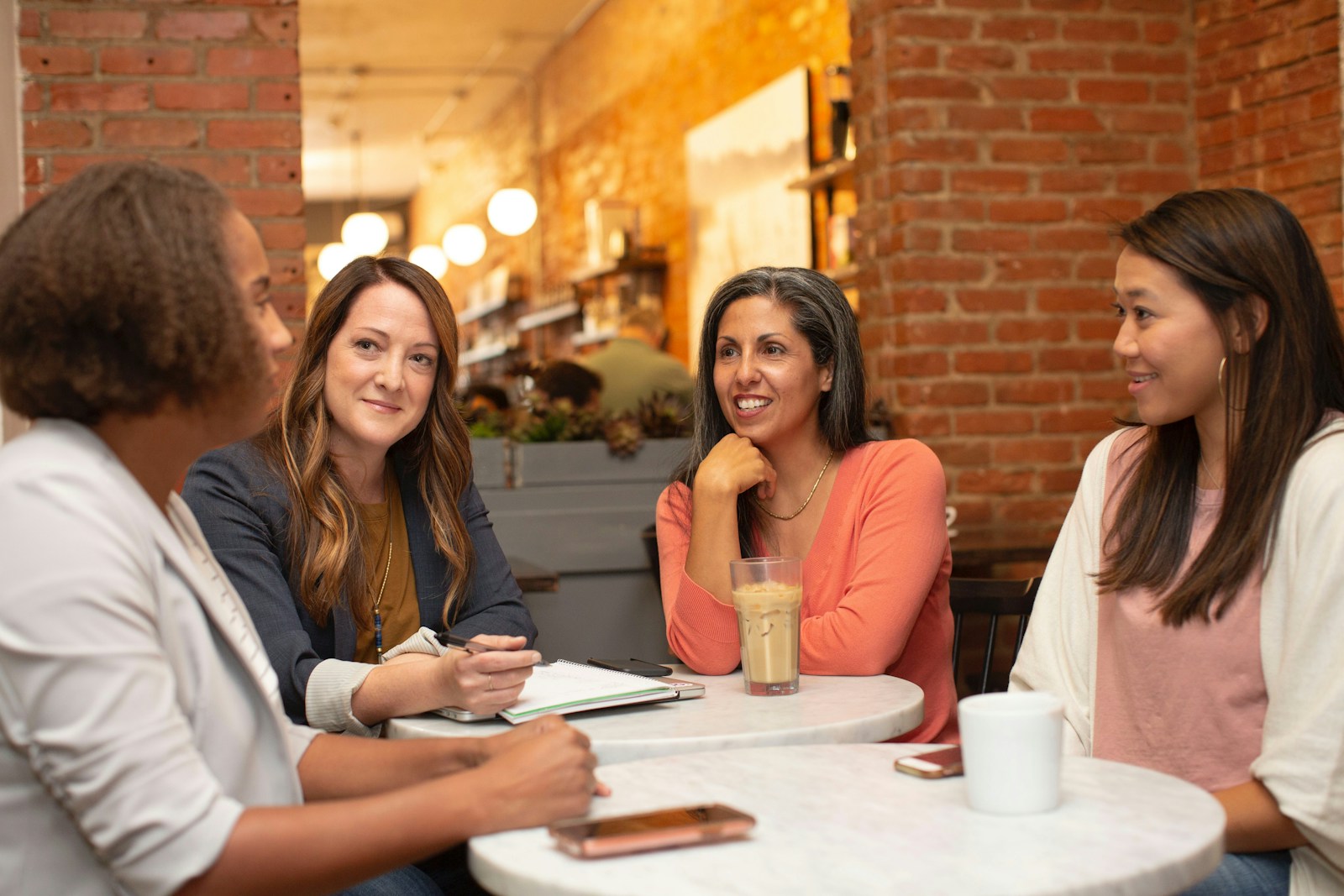Photo by LinkedIn Sales Solutions woman in black jacket sitting beside woman in white blazer