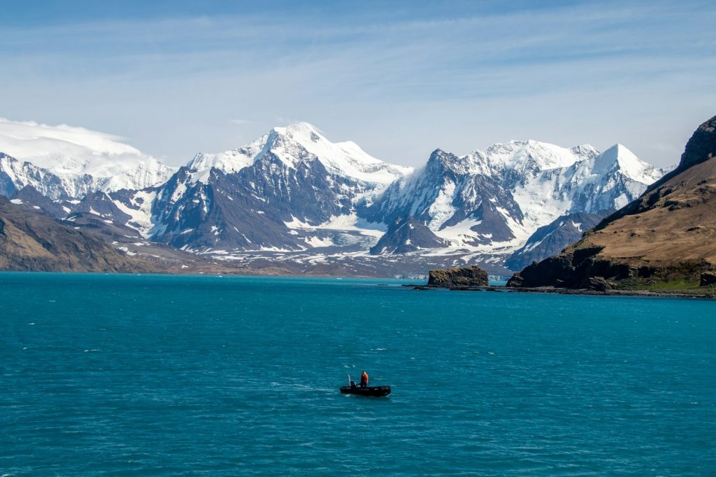 A boat in a large body of water with mountains in the background