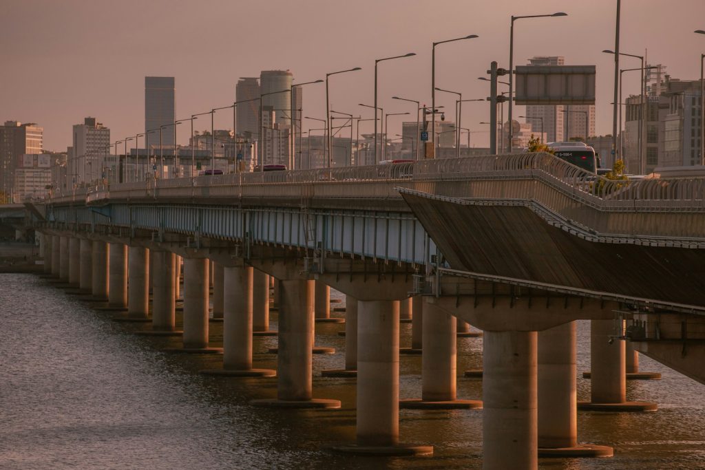 a bridge over a body of water with a city in the background