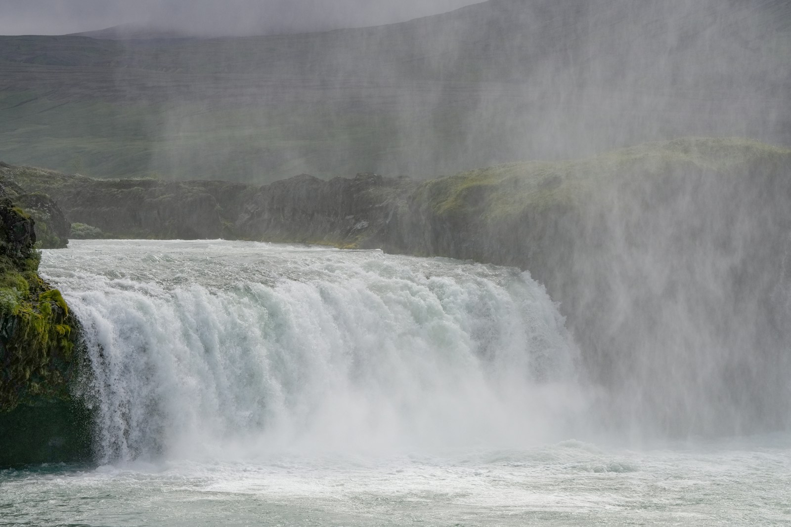Photo by Markus Kammermann a large waterfall with water pouring out of it