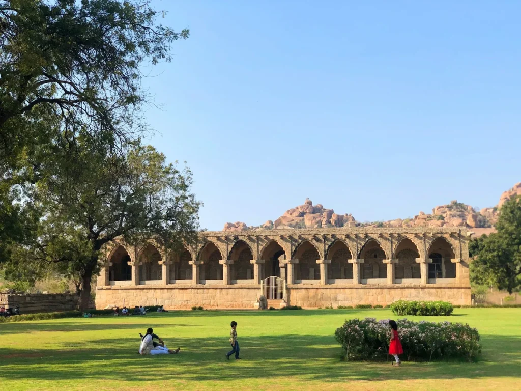 people sitting on green grass field near brown concrete building during daytime